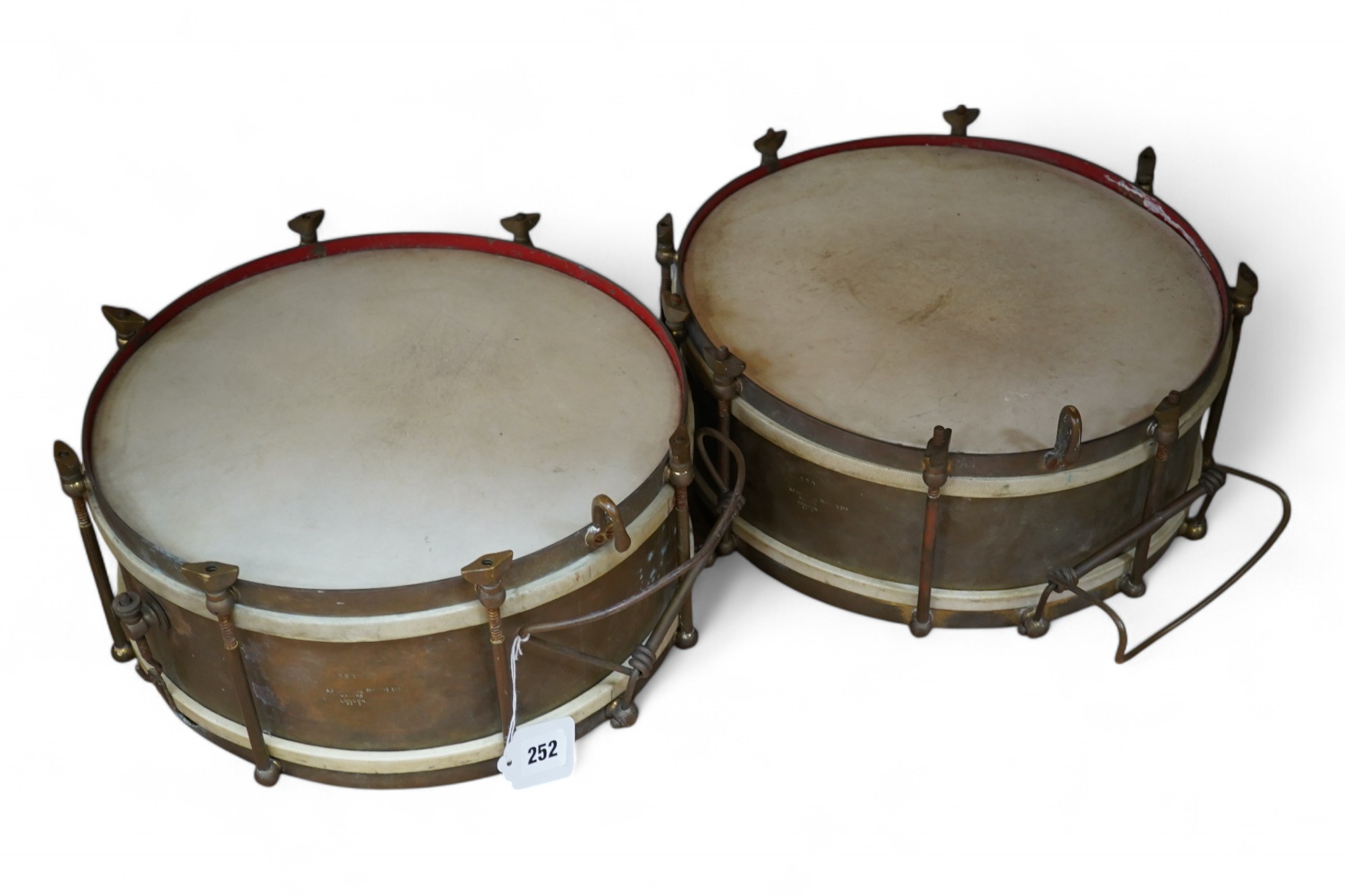 A pair of A H Matthews military brass side drums, both stamped London 1949, 35.5cm diameter skin. Condition - fair.